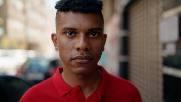 istock Young latin man with relaxed expression standing at street 1437889079