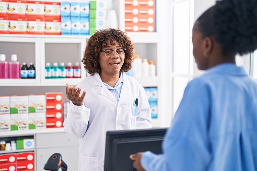 African american women pharmacist and customer speaking at pharmacy