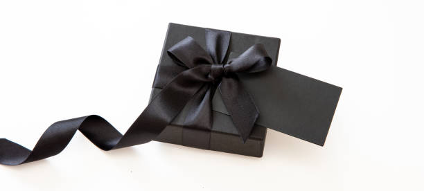 istock Black Friday Sale. Gift box with black ribbon and empty card isolated on white 1437892684