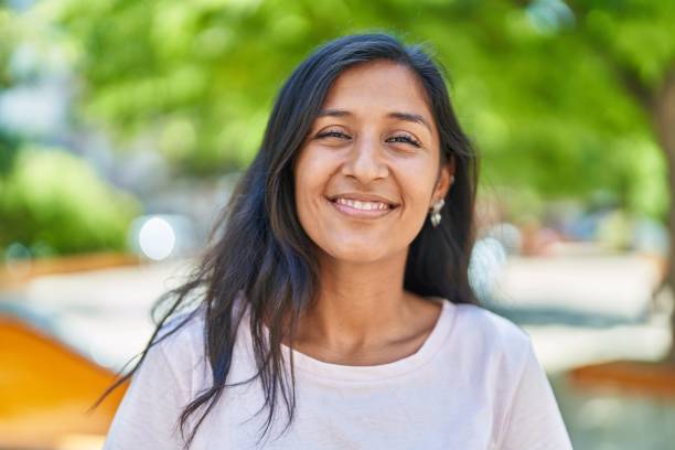 Young beautiful hispanic woman smiling confident standing at park stock photo