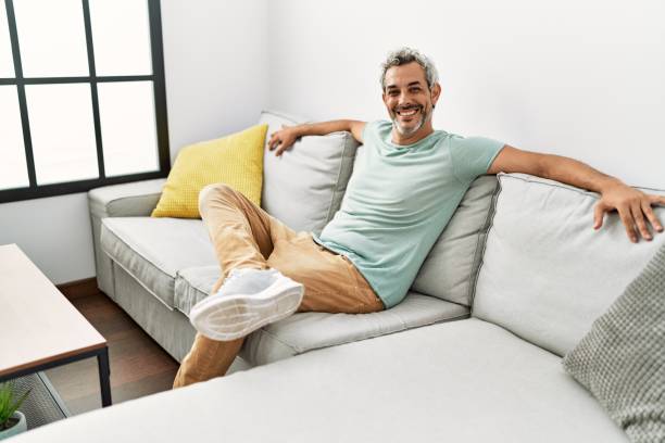 istock Middle age grey-haired man smiling confident sitting on sofa at home 1437894186