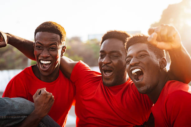 African football fans having fun supporting their favorite team - Sport entertainment concept stock photo