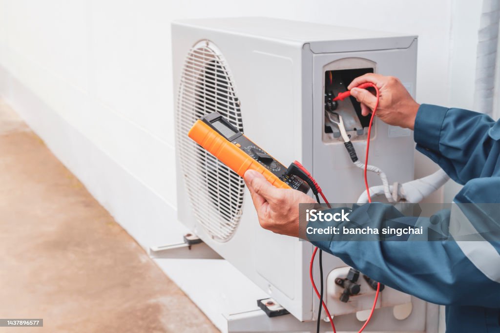 Air conditioner technician repairing central air conditioning system with outdoor tools Air Conditioner Stock Photo