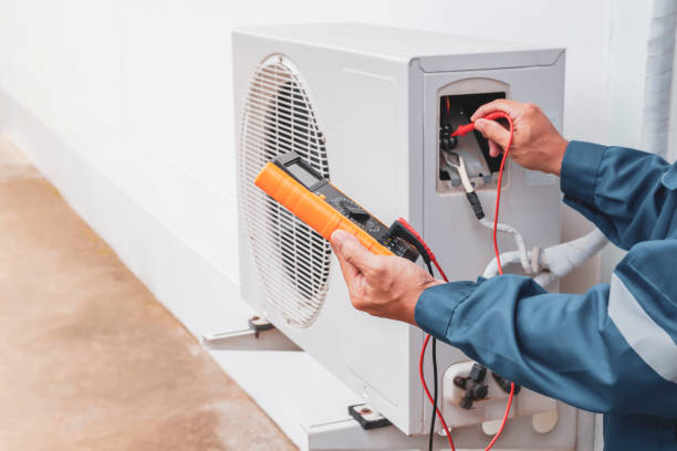 Air conditioner technician repairing central air conditioning system with outdoor tools stock photo
