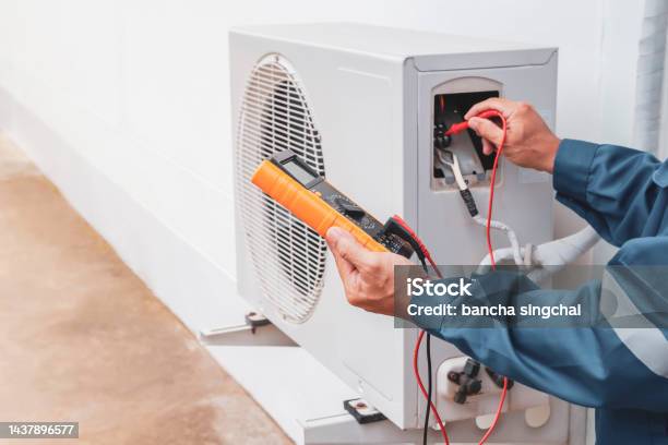 Air Conditioner Technician Repairing Central Air Conditioning System With Outdoor Tools Stock Photo - Download Image Now