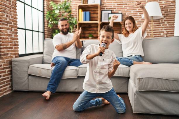 Family singing song using microphone at home stock photo
