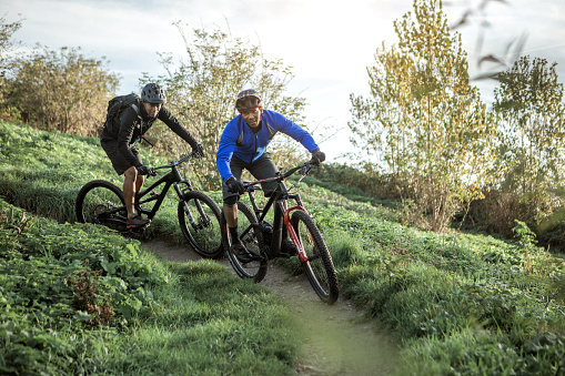 Two black mountain bikers enjoying the exercise on an outdoor biking trail