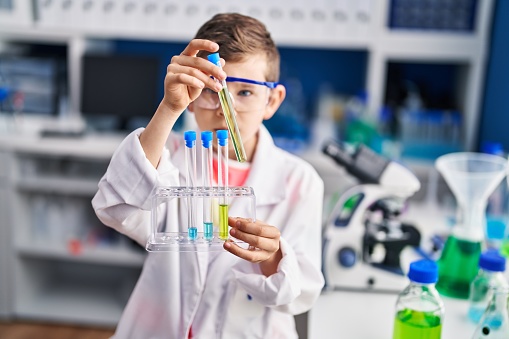 Close-up of girls hands adding liquid in test tube