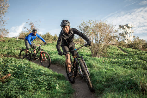 Two black mountain bikers on the trail stock photo