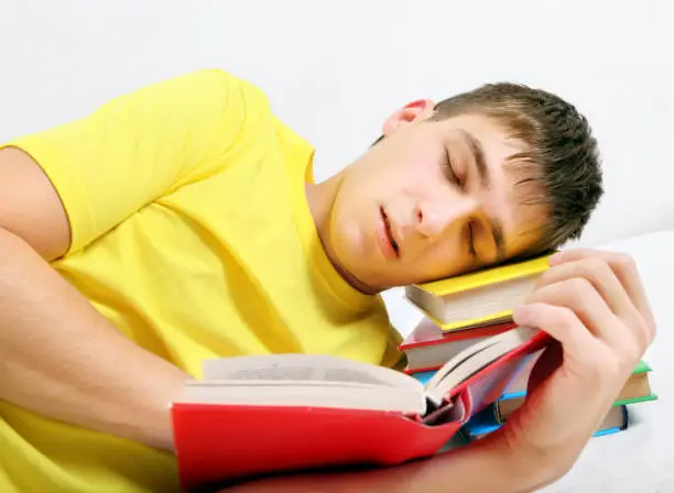 Tired Student sleep on the Book on the White Background