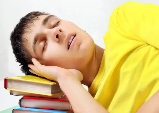 Teenager sleep on the Books on the White Background