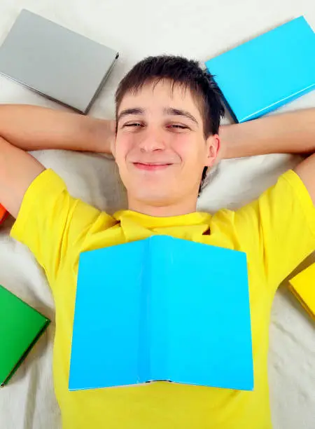 Cheerful Teenager with a Books on the Bed