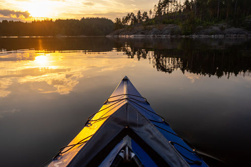 Ladoga lake. Panorama of the Republic of Karelia. Northern nature of Russia. View from the blue kayak from the water. Boots on the bow of the boat.