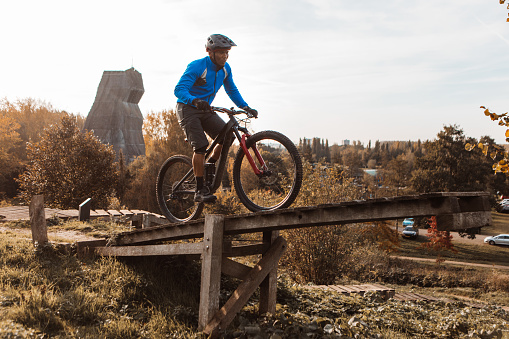 An adventurous black mountain biker alone on the trail