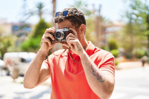 istock Young hispanic man tourist using vintage camera at street 1437899744