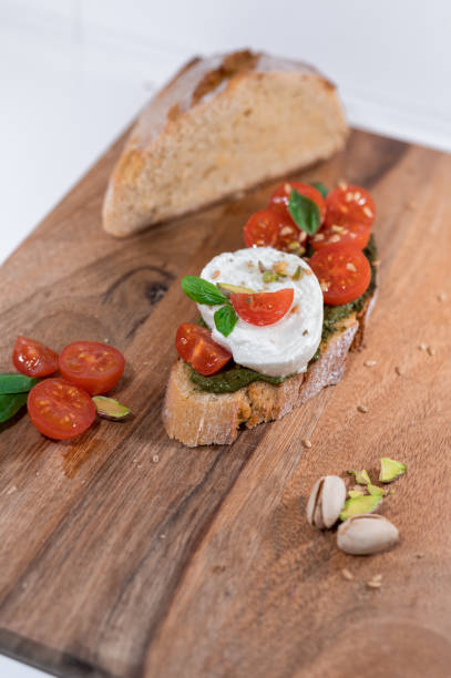 istock tomato cheese green basil mozzarella bread toast wood table 1437901110