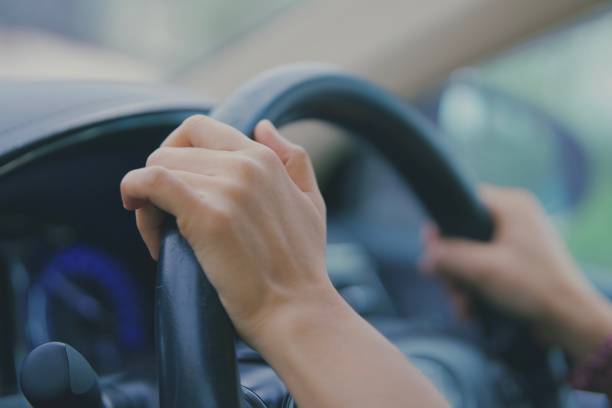 istock woman's hand, holding, steering wheel, car, driving. 1437902008