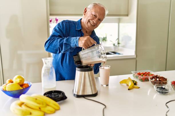istock Senior man smiling confident pouring smoothie on glass at kitchen 1437903296