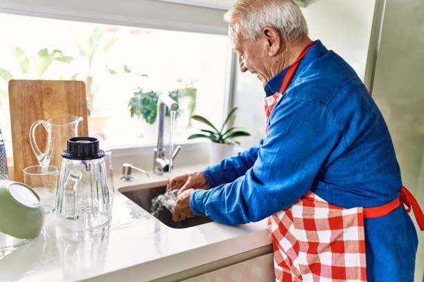 istock Senior man smiling confident washing glass at kitchen 1437903306