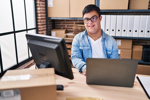 Down syndrome man ecommerce business worker using laptop working at office