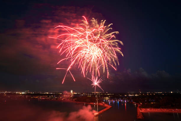 istock Aerial view of bright fireworks exploding with colorful lights over sea shore on US Independence day holiday 1437909210