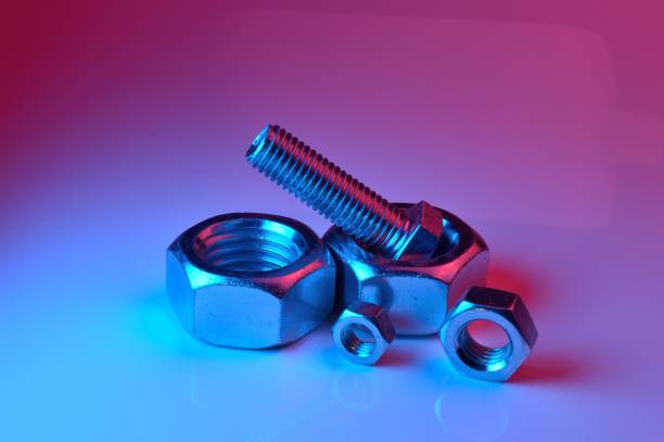 istock large and small nuts and bolts, highlighted in different colors, on a light background. 1437909554
