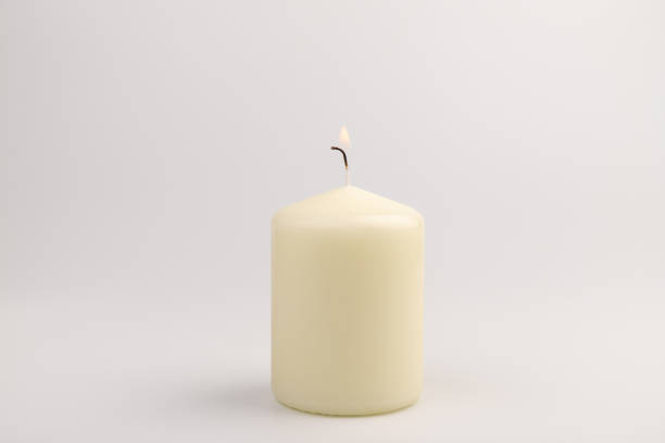 istock Burning white wax candles on white background. 1437912590
