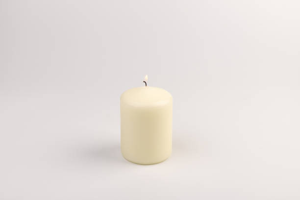 istock Burning white wax candles on white background. 1437912676