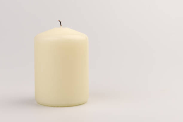 istock Burning white wax candles on white background. 1437912713
