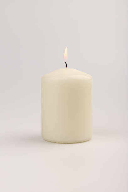 istock Burning white wax candles on white background. 1437912726