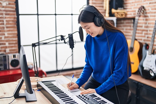 Músico chino componiendo canción en estudio de música photo