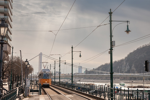 Picture of a Ganz CSMG tram ready for departure on a tram stop in pest district in Budapest, Hungary by the danube river. The tram network of Budapest is part of the mass transit system of Budapest, the capital city of Hungary. The tram lines serve as the second most important backbone of the transit system