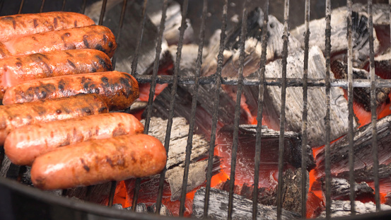 Closeup of sausage on the grill. Sausages are grilled BBQ. Grilled sausage on the flaming grill.