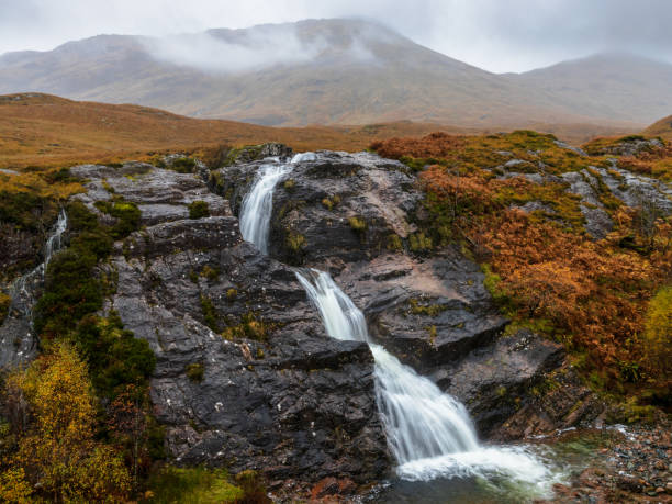 istock Glencoe waterfall with mountains in the background 1437915613