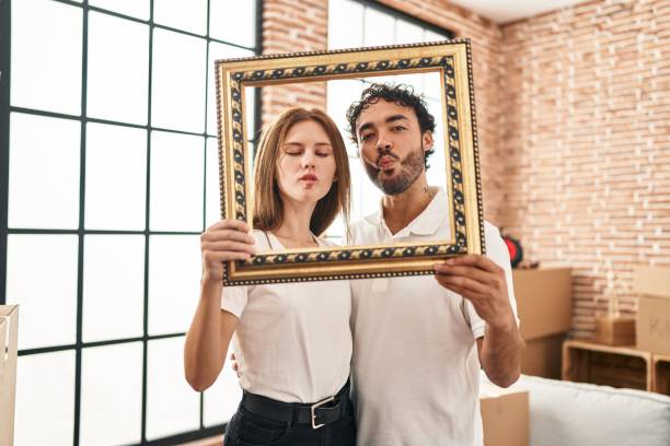 istock Young two people holding empty frame together making fish face with mouth and squinting eyes, crazy and comical. 1437917287