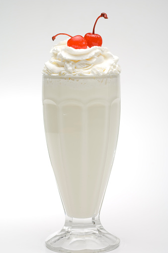 Vanilla milkshake with whipped cream, and cherries.