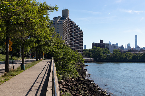 A sidewalk along the East River riverfront at Astoria Park during the summer in Astoria Queens of New York City
