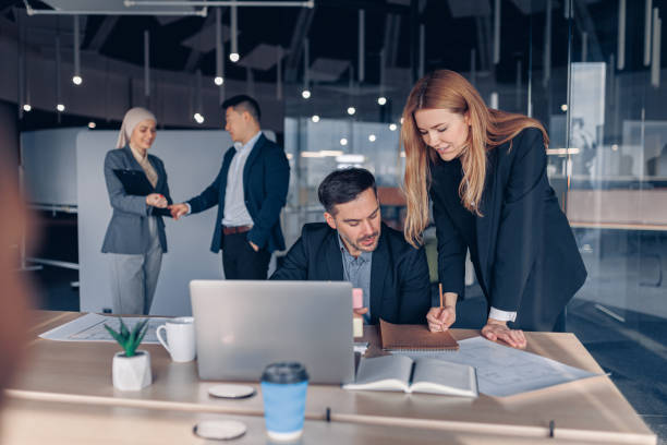 istock Two smiling coworkers working together analyzing the charts in office on colleagues background 1437921011