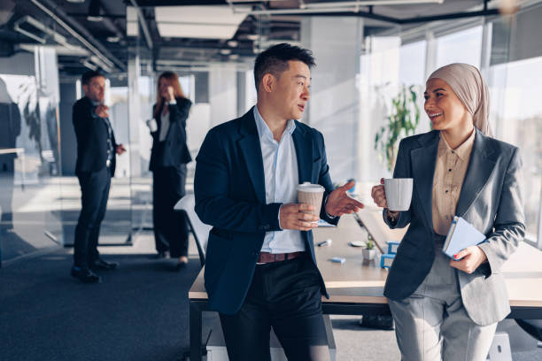 istock Two happy multiracial colleagues talking and drinking coffee during break time in office 1437921111