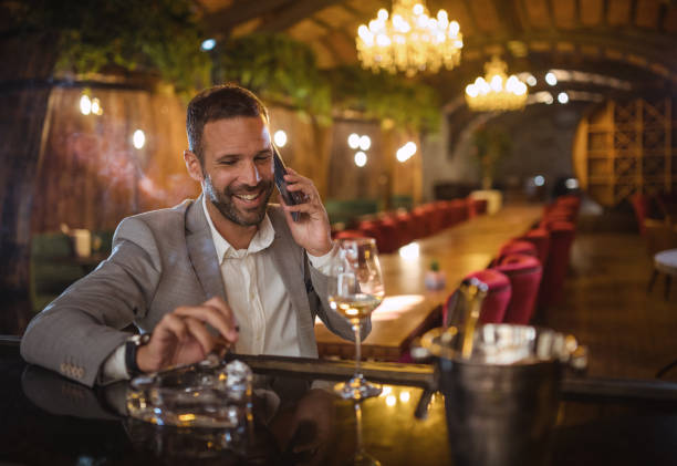 istock Young businessman drinking wine and smoking a cigarette 1437921494