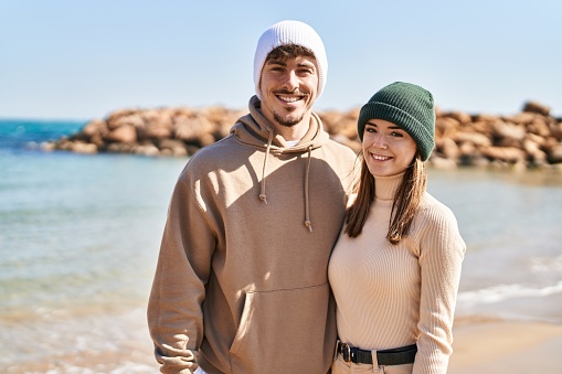 Mand and woman couple smiling confident standing together at seaside