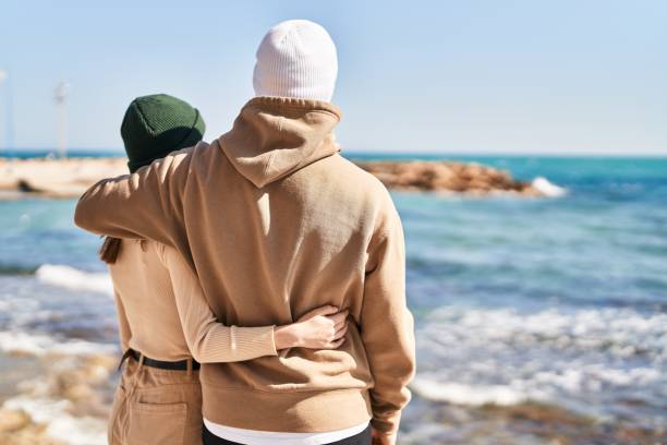Mand and woman couple hugging each other at seaside stock photo