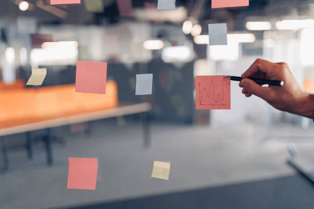 istock Businessman hand's is writing on sticky notes on board in modern office 1437923467