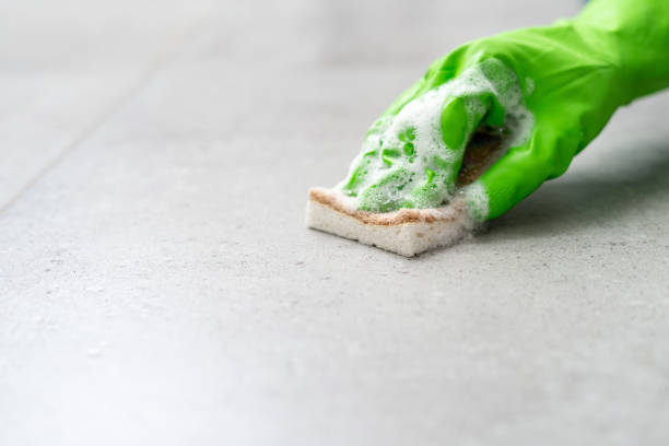 istock gloved hand cleaning floor with sponge and detergent foam, closeup 1437925396