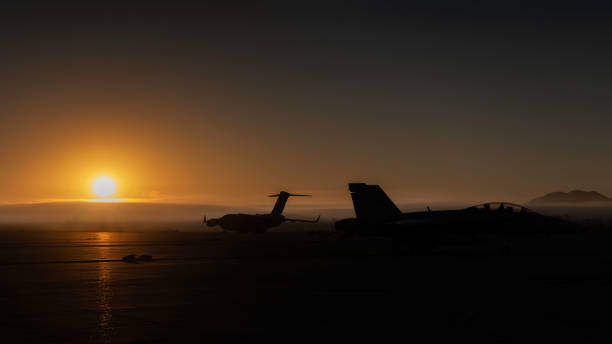 Sunrise on the Tarmac Miramar, California, USA - September 25, 2022: An FA-18 Hornet and C-17 Globemaster sit on the tarmac before the crowds arrive at the 2022 Miramar Airshow. fa 18 hornet stock pictures, royalty-free photos & images