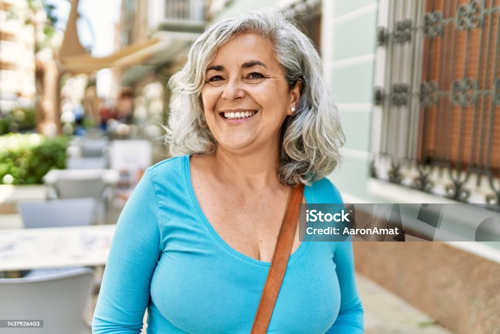 Middle age grey-haired woman smiling happy standing at the city. Latin American and Hispanic Ethnicity Stock Photo