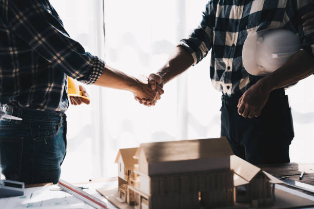 istock Businessman handshake with engineering in construction renovate building site. Engineer/architect inspection workplace for project.Teamwork construction engineer,business and architecture concept. 1437928397