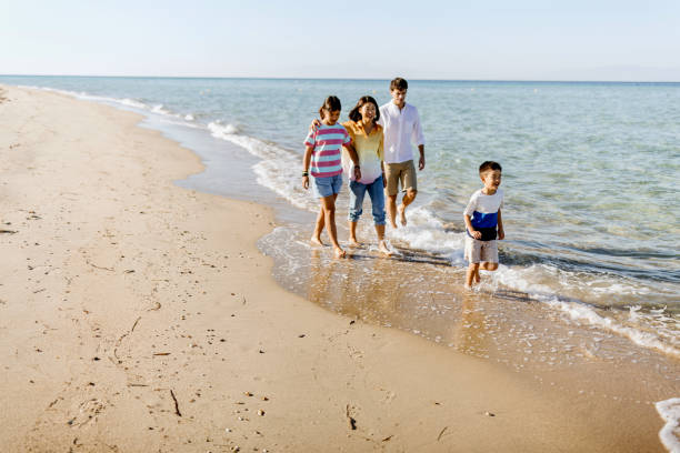 istock Parents walking Along Beach With Children On Summer Vacation 1437928617