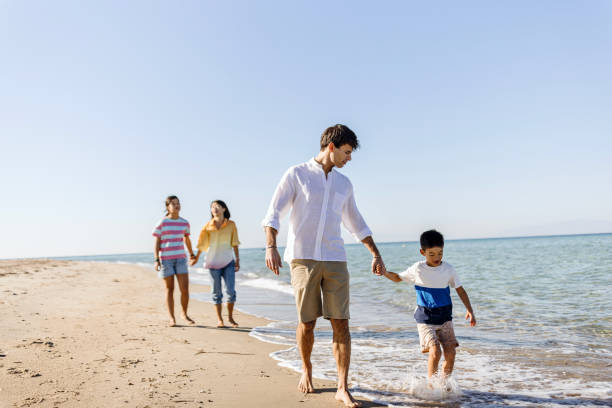 istock Parents walking Along Beach With Children On Summer Vacation 1437928629