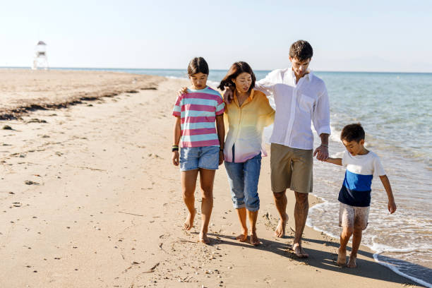 istock Parents walking Along Beach With Children On Summer Vacation 1437928737
